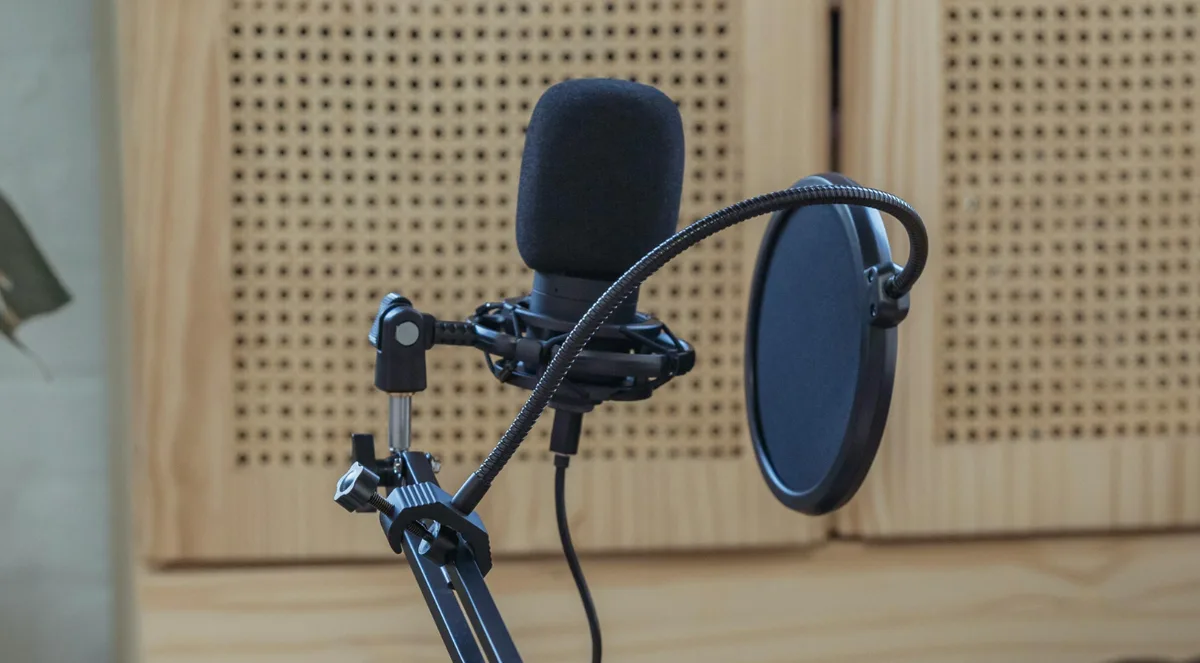 Condenser microphone with pop filter on boom arm — correct mic distance setup